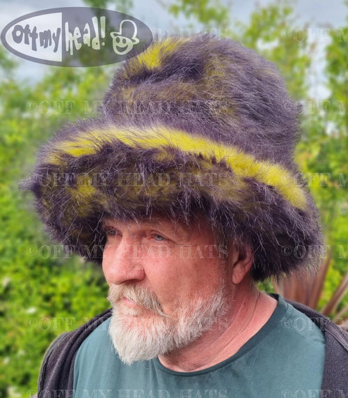 Man wearing a large, fluffy hat with yellow and black.
